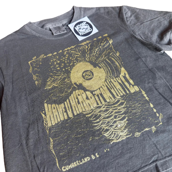 Gray t-shirt with yellow graphic design on a wooden surface