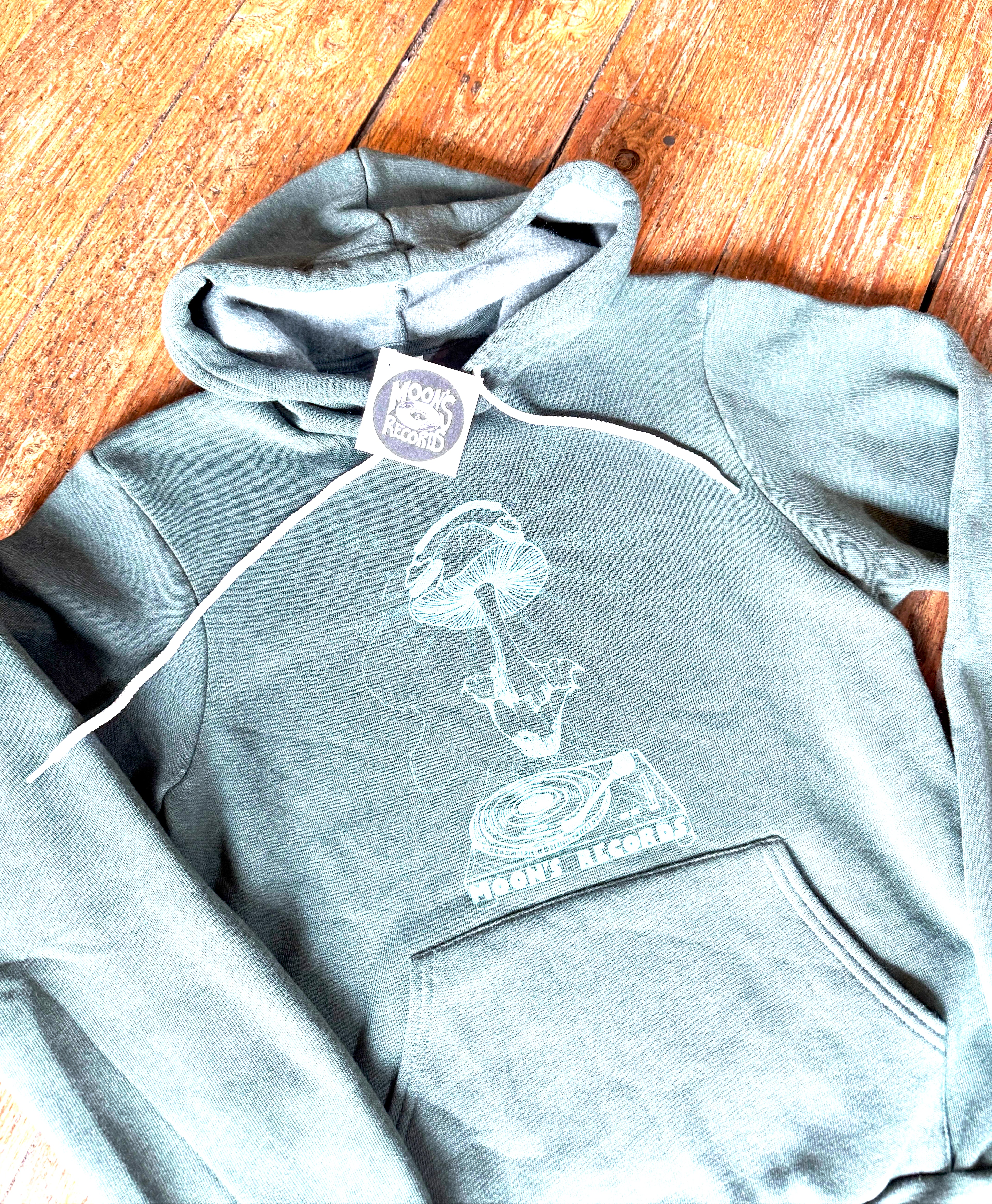 Gray hoodie with a graphic design on a wooden floor