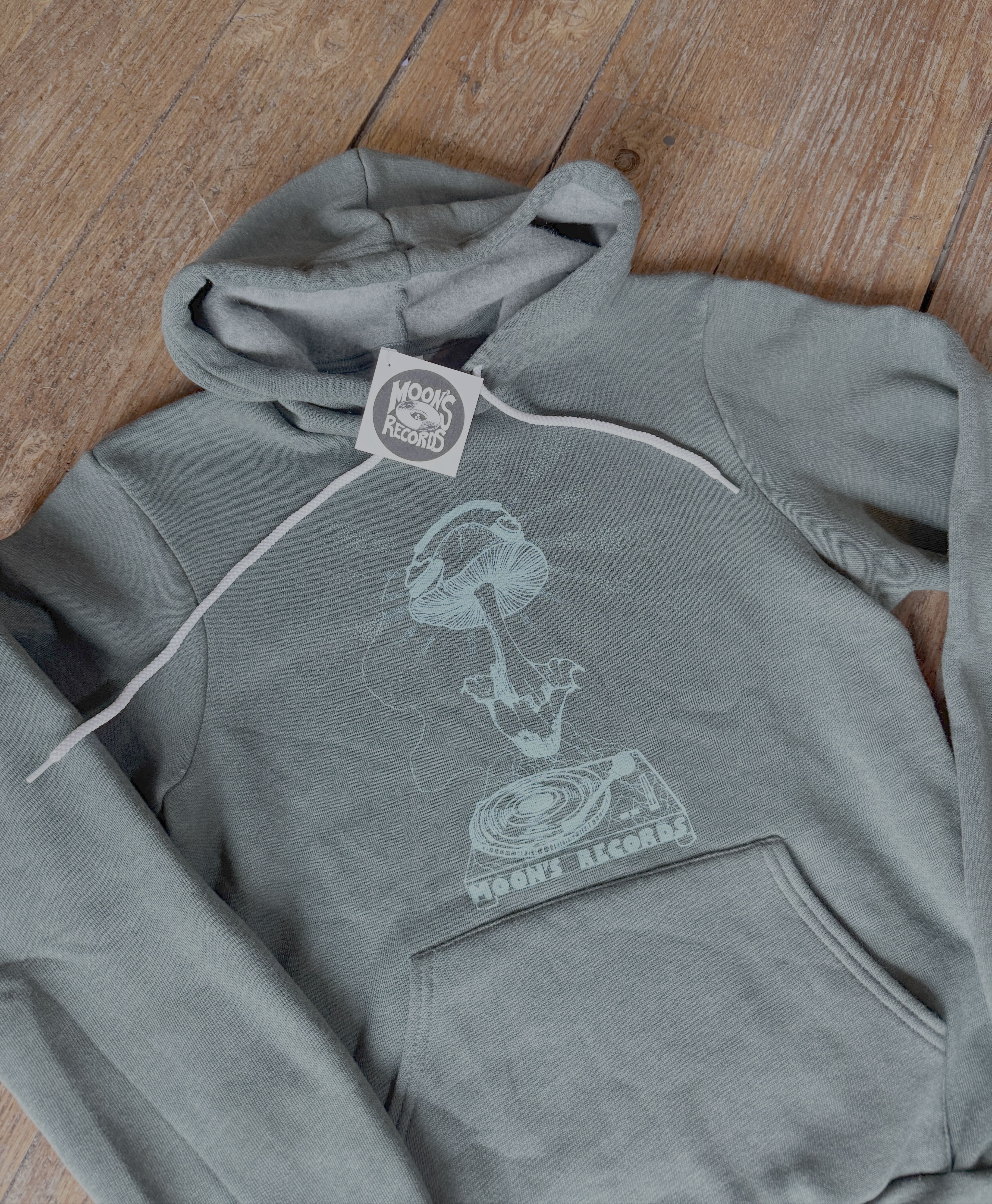 Gray hoodie with a graphic design on a wooden floor